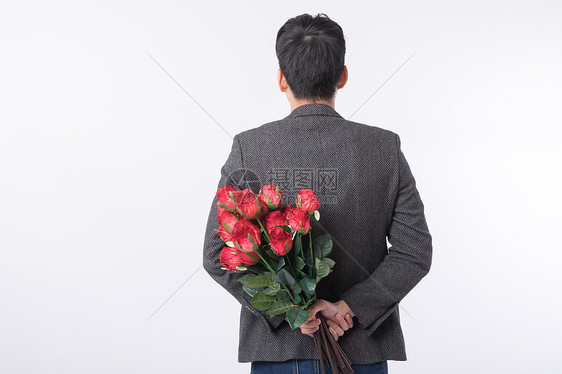 手拿玫瑰花的男性背影图片