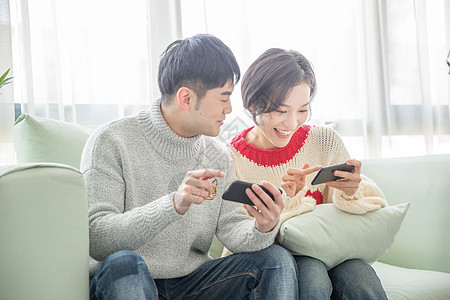 居家年轻情侣在沙发上玩手机游戏图片