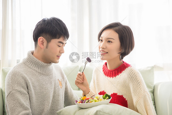 居家情侣在沙发上吃蔬菜沙拉图片