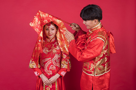 传统中式婚礼新郎掀起新娘的红盖头背景图片