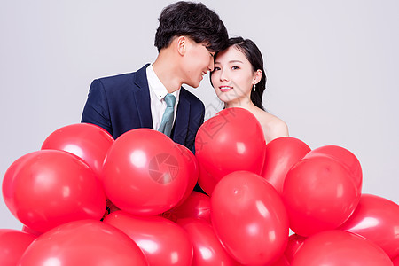 情侣手持红色爱心气球图片