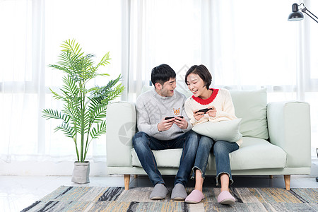 年轻情侣在客厅玩手机游戏高清图片