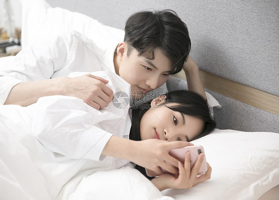 情侣在床上玩手机图片