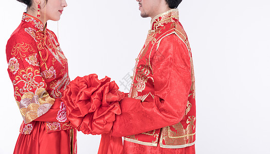 身着中式礼袍的年轻夫妻特写图片