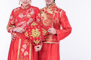 身着中式礼袍的年轻夫妻特写图片