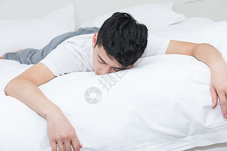 年轻男性沮丧地躺在床上高清图片