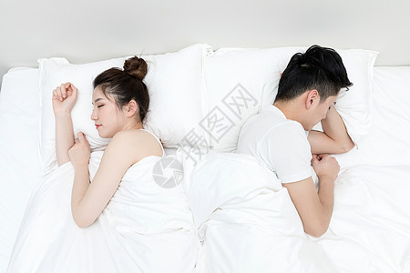 背对背睡觉冷战的年轻情侣背景图片