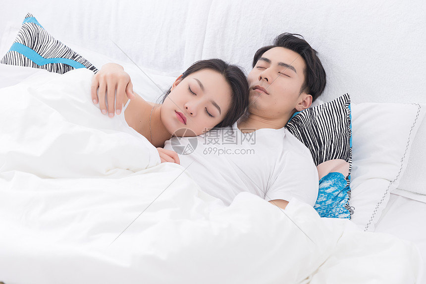 年轻夫妻拥抱躺床上休息图片