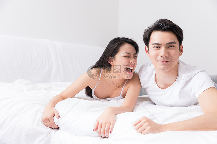 年轻夫妻开心躺在床上图片