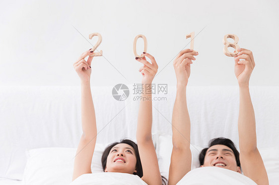 年轻夫妻躺床上手拿2018图片