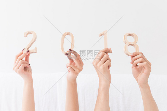 年轻夫妻躺床上手拿2018特写图片