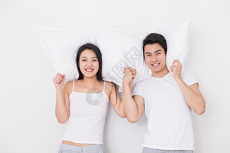 年轻夫妻枕着枕头在一起图片
