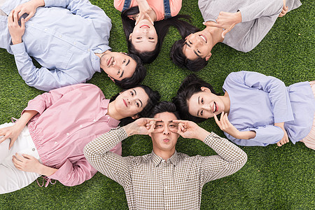 青年聚会众人开心躺草地上背景图片