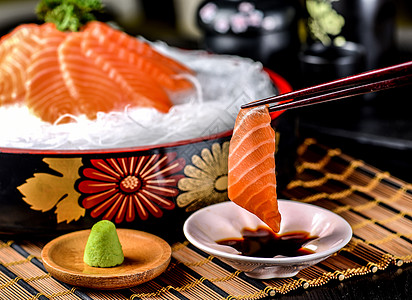 筷子夹起来的三文鱼刺身图片