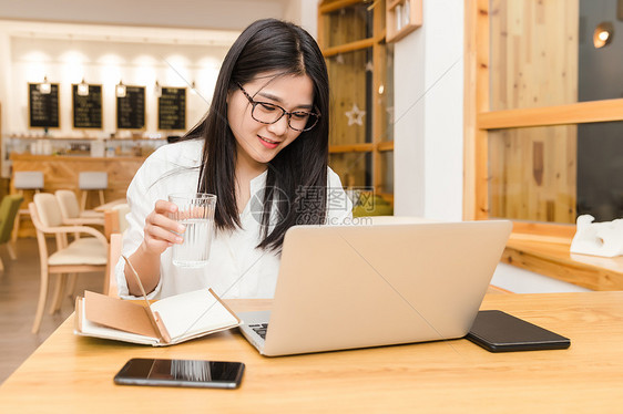 年轻女性咖啡馆内喝水图片