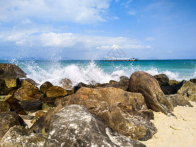 船浪花浪花拍打着海滩边的巨石背景