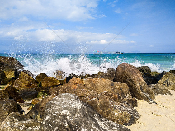 浪花拍打着海滩边的巨石图片