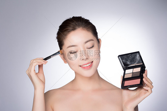 年轻女性化妆涂眼影图片