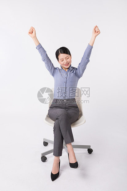 坐在椅子上伸懒腰放松的职场女性图片