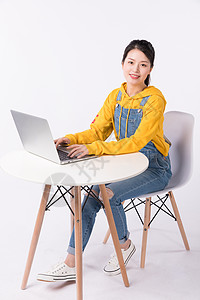 坐在椅子上使用电脑的学生图片