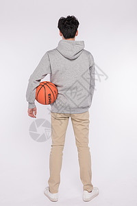 拿着篮球的男生背影背景图片