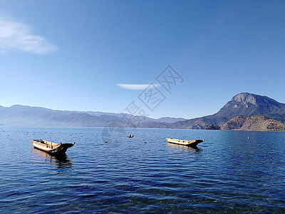 船在湖倾斜两只船儿漂浮在静静的湖面背景