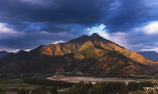 春节景色乌云阳光辉映金沙江的山体背景