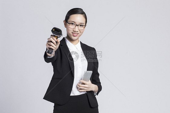拿着手机扫码的职业女性图片