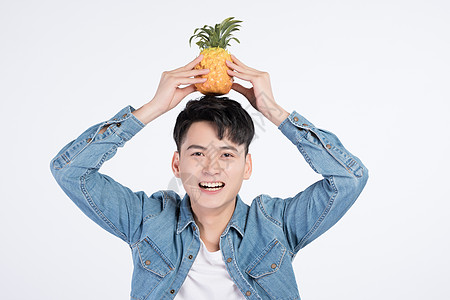 手拿菠萝男性手持菠萝的青年男性背景