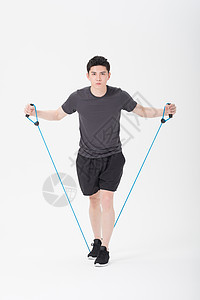 青年男子使用阻力带健身塑身背景图片