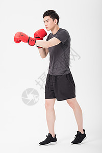 健身男性戴拳击手套打拳出拳背景图片