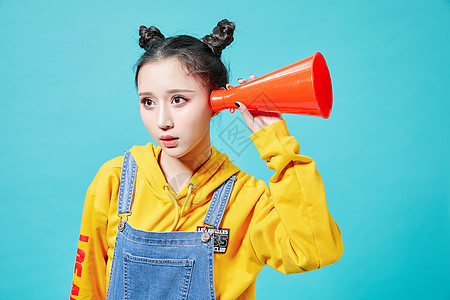 美女鲜艳青年女性拿着听筒听的动作背景