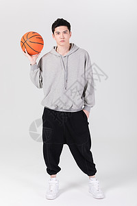 拿着篮球打篮球的年轻男生背景图片