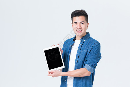 年轻男性手拿平板电脑展示使用背景图片