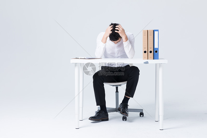 坐在办公桌前低头沮丧的商务白领图片