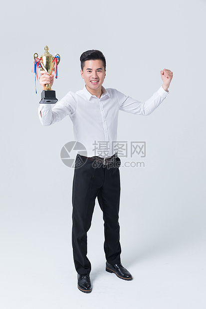 商务男性手拿冠军奖杯开心欢呼图片