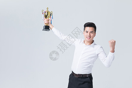商务男性手拿冠军奖杯开心欢呼图片