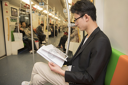 地铁上看书商务男士在地铁里阅读背景