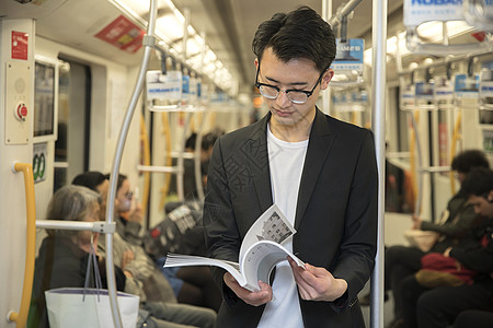 商务男士在地铁里阅读图片