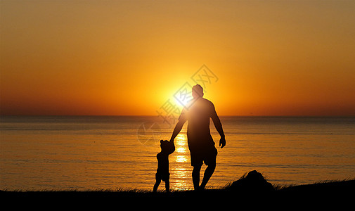 爸爸与儿子玩耍夕阳下父子剪影设计图片