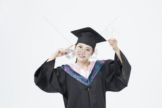 拿着灯泡的毕业女大学生图片