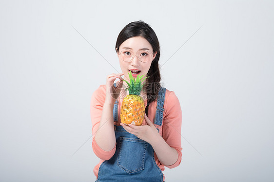 年轻美女手拿菠萝拍照