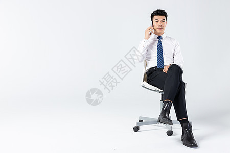 商务男士坐椅上打电话图片