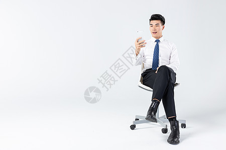 商务男士坐椅上用手机图片