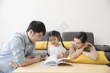 一家人在新家客厅里一起看书阅读高清图片