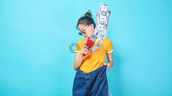 青年时尚女性手持喷钱枪图片