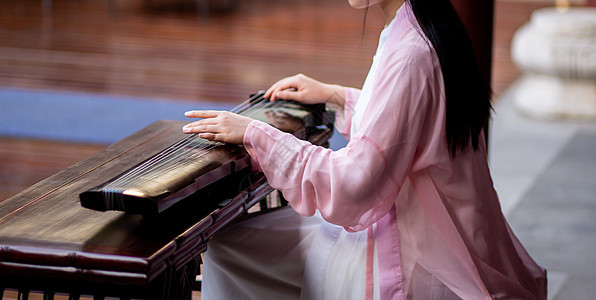 穿中国传统服饰的女性弹奏古琴图片