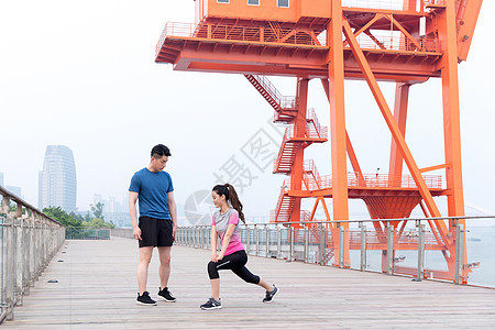 教练指导年轻女子热身运动户外锻炼图片