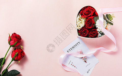 粉色背景上装满鲜花的礼物盒图片