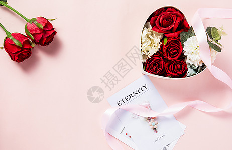 粉色背景上装满鲜花的礼物盒图片
